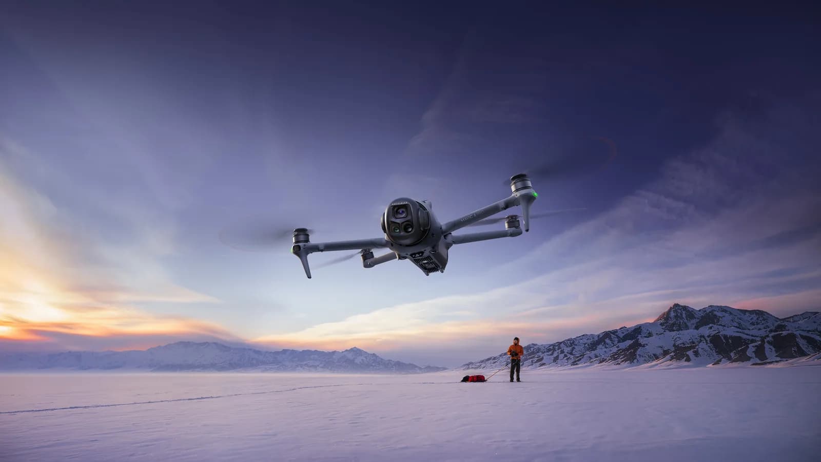 DJI Mavic 4 Pro en vol au-dessus d'une plaine enneigée au coucher du soleil
