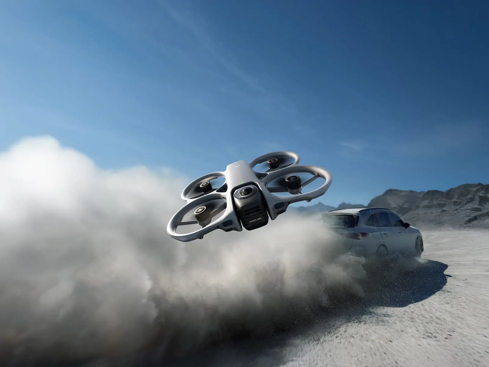 DJI Avata 360 en vol rasant près d'une voiture soulevant un nuage de poussière dans le désert