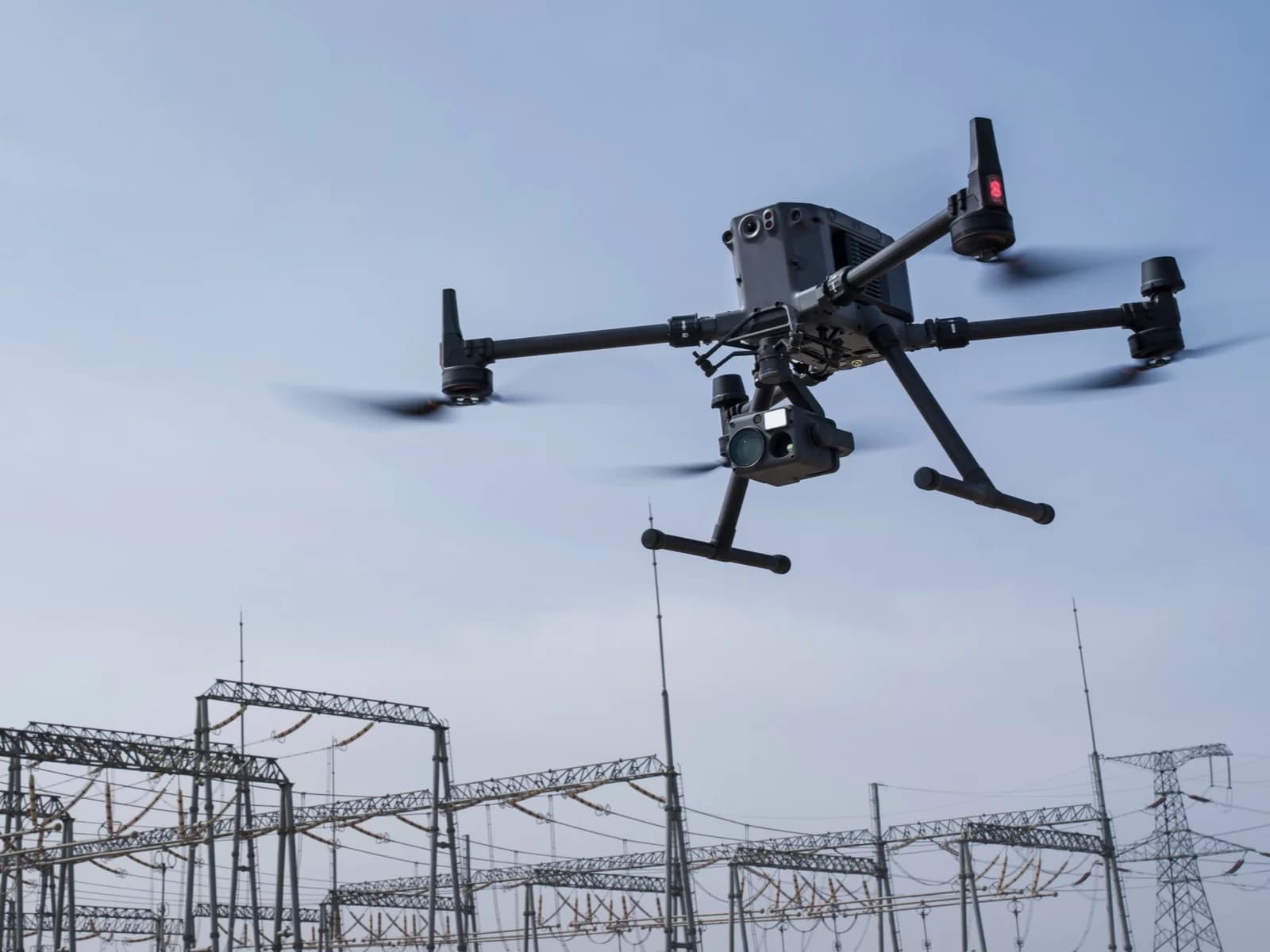 DJI Matrice 350 RTK en vol d'inspection au-dessus d'un poste électrique haute tension