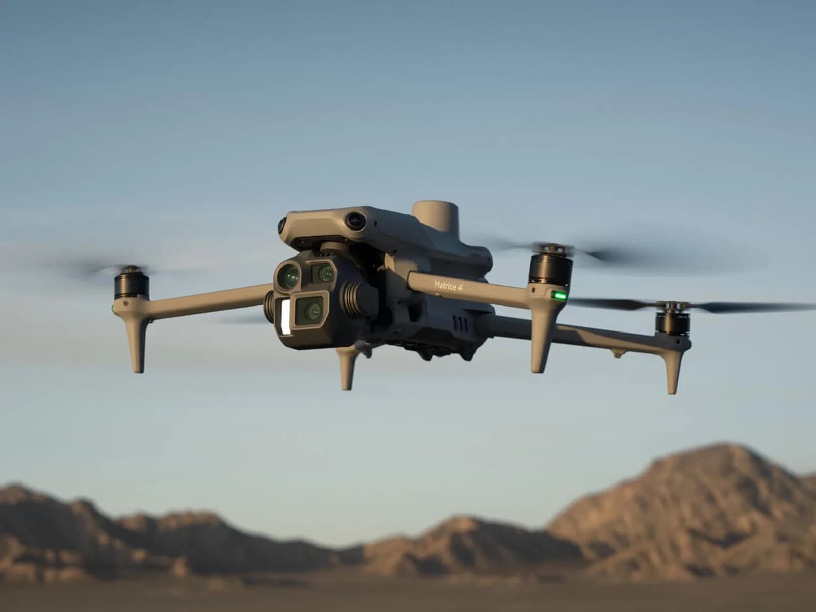 DJI Matrice 4E en vol au-dessus d'un paysage désertique, nacelle face à l'objectif