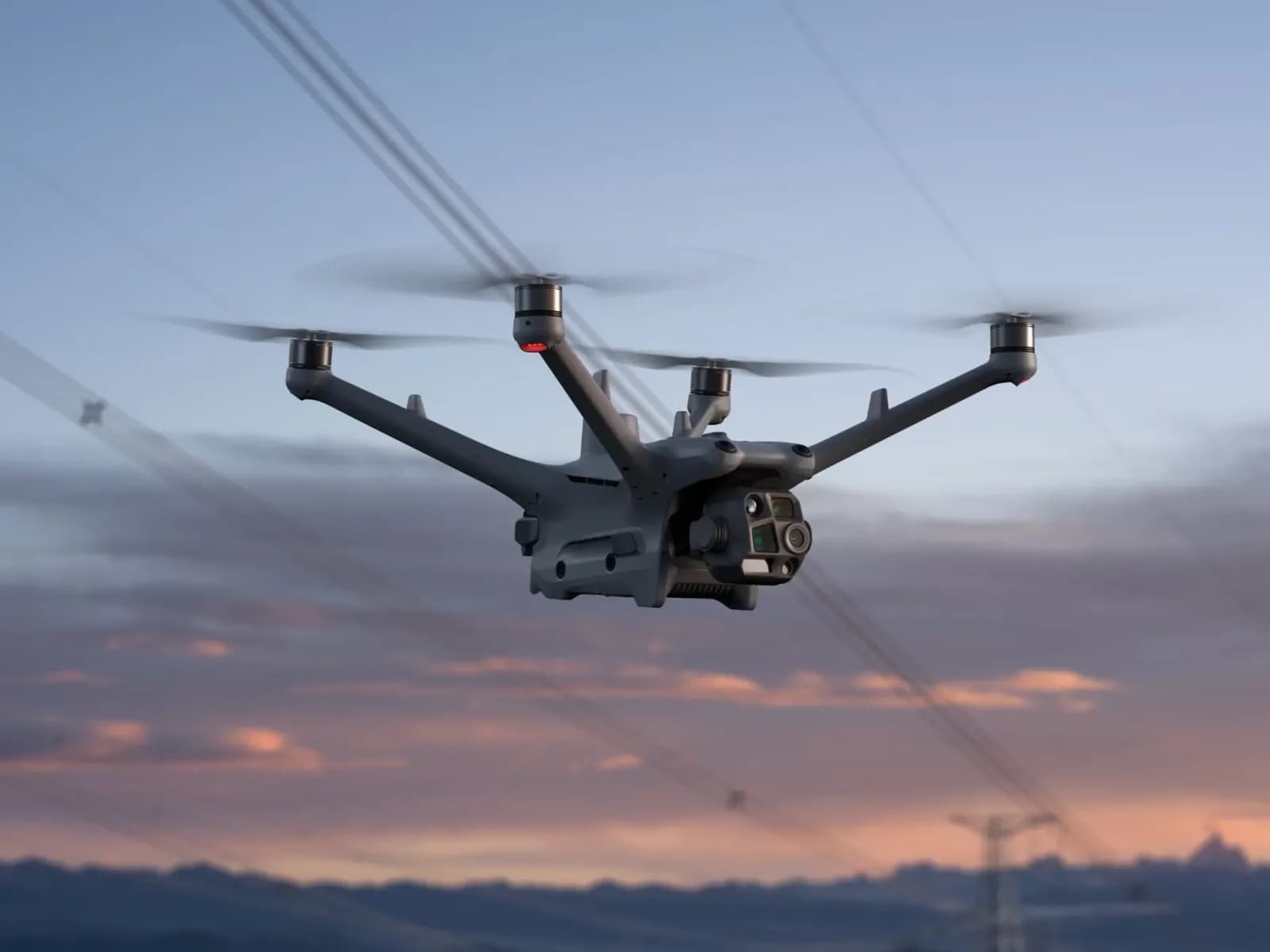 DJI Matrice 4TD en vol près d'une ligne électrique au crépuscule