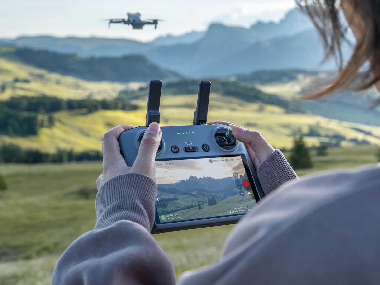 Télépilote pilotant le DJI Mini 5 Pro avec la radiocommande DJI RC 2 dans un paysage de montagne